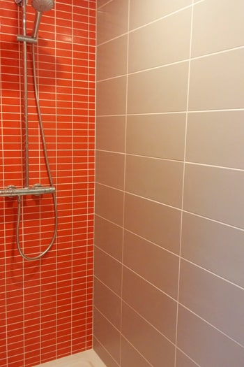 Pose d'un carrelage orange dans une douche à Mondeville