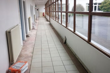 Chantier de pose d'un carrelage dans une école à Ouistreham